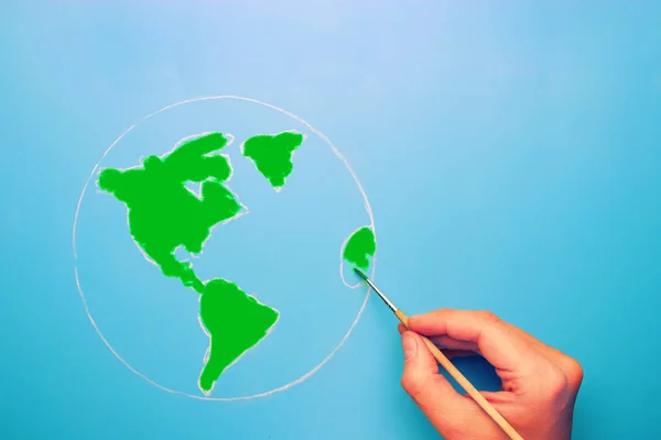 Рука з пензлем карта світу в зеленому кольорі — стокове фото