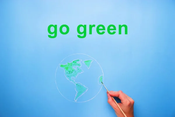 Hand mit Pinsel Weltkarte in grüner Farbe malen — Stockfoto
