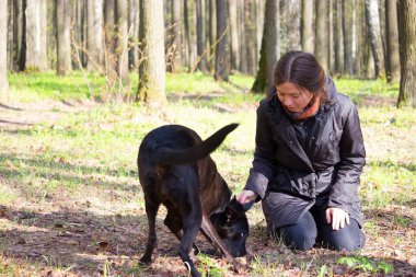 genç kadın oyun ile bir parkta siyah köpek