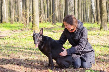 genç kadın oyun ile bir parkta siyah köpek