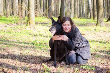genç kadın oyun ile bir parkta siyah köpek