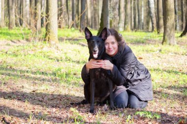 genç kadın oyun ile bir parkta siyah köpek