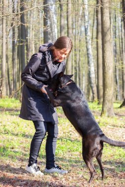 genç kadın oyun ile bir parkta siyah köpek