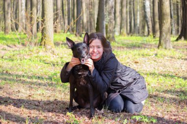 genç kadın oyun ile bir parkta siyah köpek