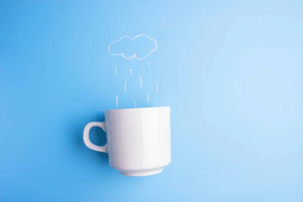 rain pouring in coffee cup on blue background