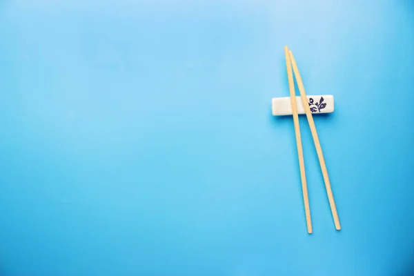 Mavi arka planda çubuklar ve soya sosu — Stok fotoğraf