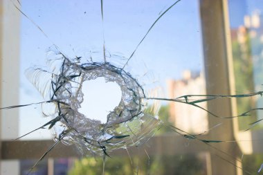 Mavi gökyüzü yansıtan kırık cam pencere