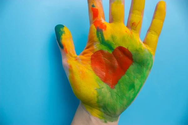 Hand in colorful paint — Stockfoto