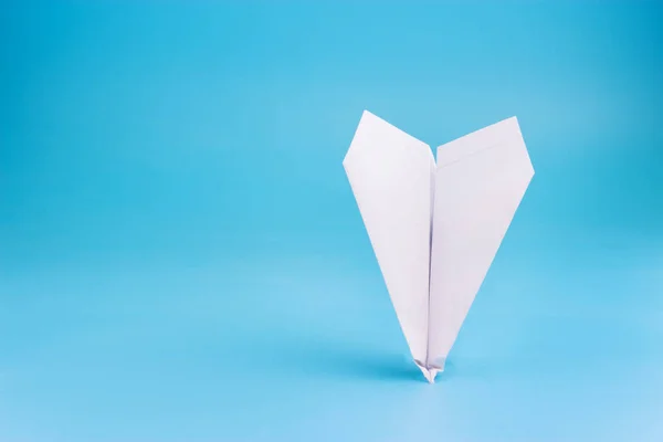 plane crash concept. paper plane upside down on blue background