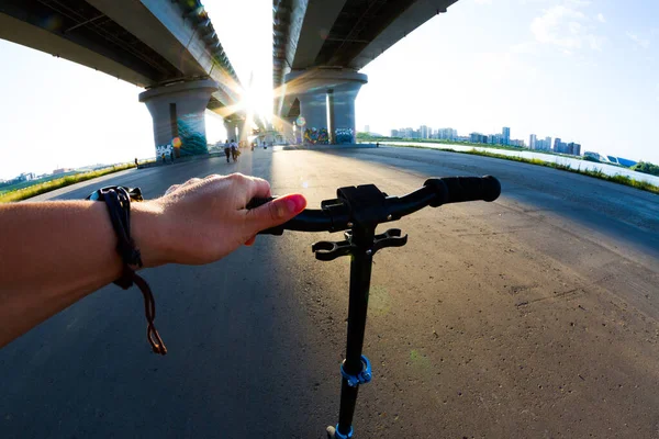 Riding scooter under bridge — ストック写真