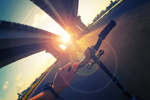 Riding scooter under bridge — ストック写真