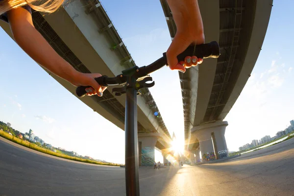 Riding scooter under bridge — ストック写真