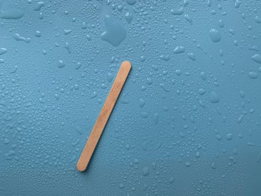 Mavi arkaplanda bir çubuk üzerindeki dondurma