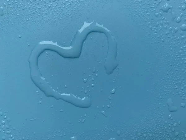 Water in heart shape on blue background