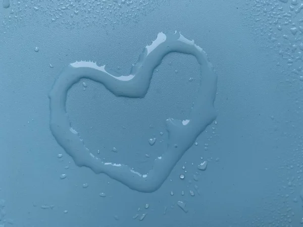 Water in heart shape on blue background