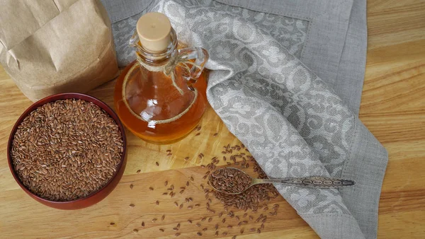 Semillas de lino en cuchara y en tazón de madera. Aceite de linaza en jarra de vidrio — Foto de Stock