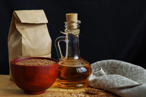 Semillas de lino en cuchara y en tazón de madera. Aceite de linaza en jarra de vidrio — Foto de Stock