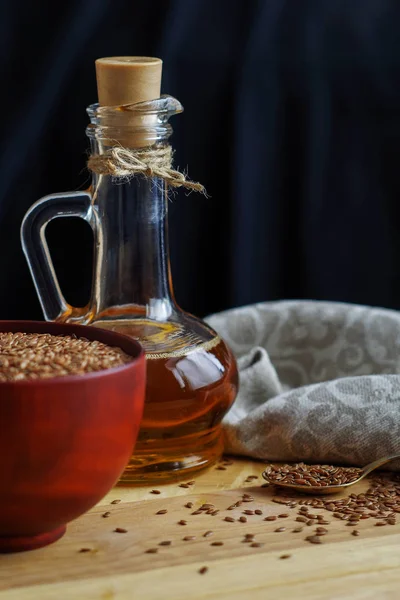 Semillas de lino en cuchara y en tazón de madera. Aceite de linaza en jarra de vidrio — Foto de Stock