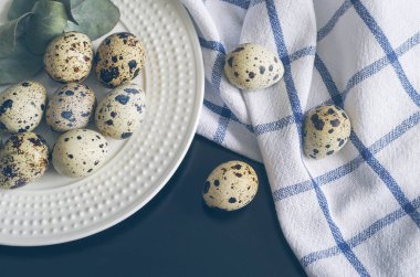 Tablo ayarı ile beyaz tabak, kumaş peçete, bıldırcın yumurtası