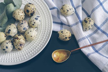 Tablo ayarı ile beyaz tabak, kumaş peçete, bıldırcın yumurtası