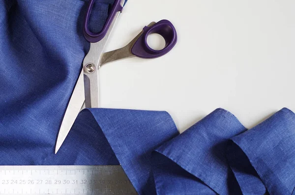 Textilien messen und schneiden. Schere und violettes Leinengewebe. — Stockfoto