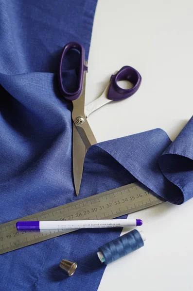 Textilien messen und schneiden. Schere und violettes Leinengewebe — Stockfoto
