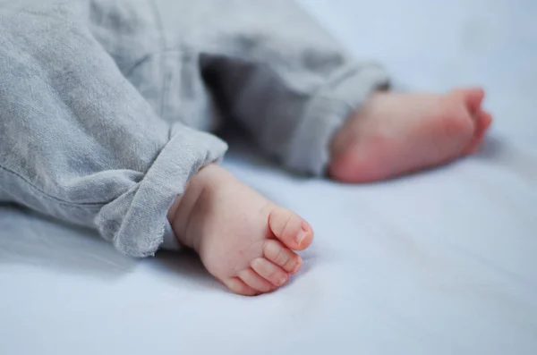 Голые Ноги Новорожденного Ребенка Серых Заправленных Штанах Избирательный Фокус — стоковое фото