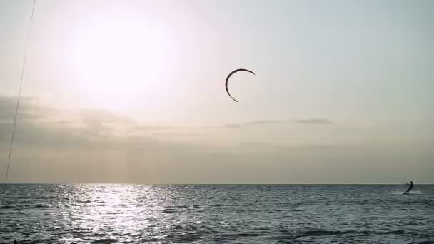 Kitesurfing. The eight dark silhouettes of surfers riding on boards on the waves of Azov sea at sunset. HD
