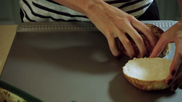 Vaření hamburger. Ženské ruce rozložení tři řezu chleba rolích na stůl. HD