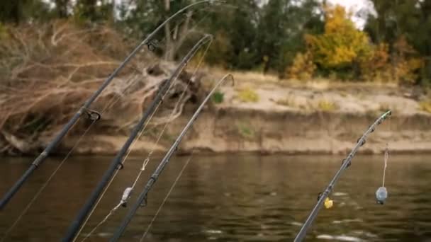 Catching fish. Four fishing rods placed on a motor boat floating on the background of the bank river. HD — Stock Footage Catching fish. Four fishing rods placed on a motor boat floating on the background of the bank river. HD Stock Footage