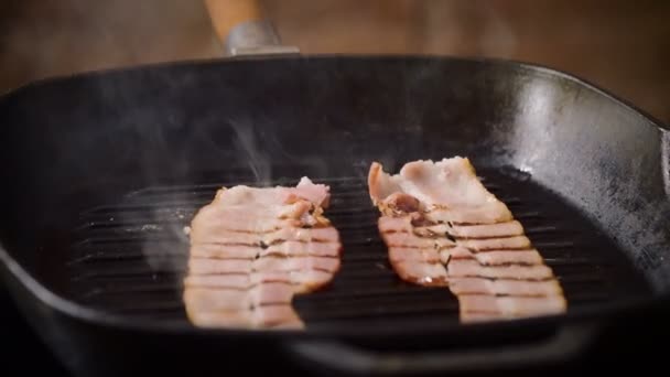 Cooking hamburger. Two narrow thin pieces of smoked bacon are being fried in a broiler pan for burger. 4K — Stock Footage Cooking hamburger. Two narrow thin pieces of smoked bacon are being fried in a broiler pan for burger. 4K Stock Footage