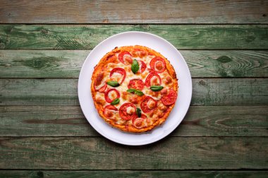 Peynir beyaz tabakta lezzetli pizza. Pizza ahşap masa üzerinde