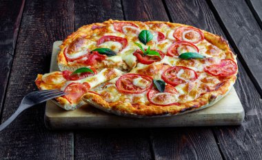 Dilim lezzetli pizza margarita ahşap masa üzerinde üzerinde çatal