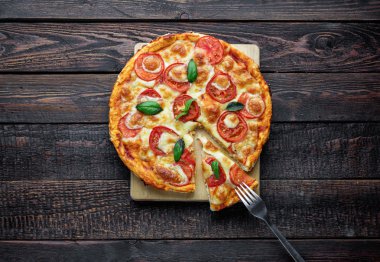 Dilim üzerinde çatal ile lezzetli pizza