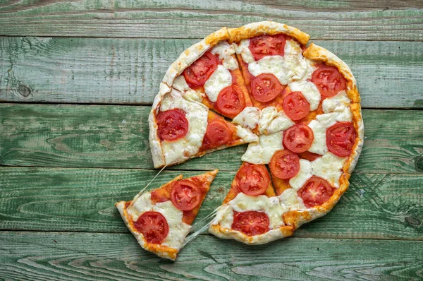 Cortar en rebanada pizza en la mesa verde. Vista superior —  Fotos de Stock