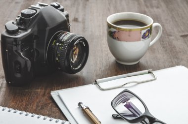 Vintage fotoğraf makinesi ve ahşap masa üzerinde kahve fincanı