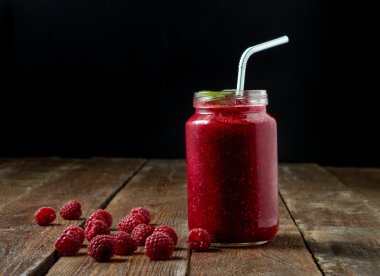 Nane, saman ve berry koyu arka plan üzerinde cam kavanoza ahududu güler yüzlü