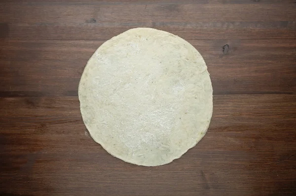 Teig für Pizza auf dunklem Holzgrund. Ansicht von oben — Stockfoto