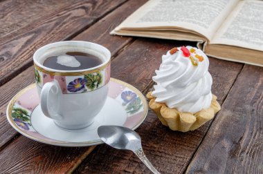 Pasta ve eski rustik masa kitap ile kahve fincanı