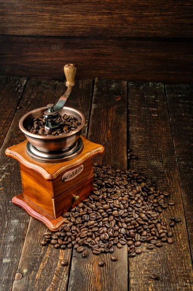 Moinho de café com grãos de café na mesa de madeira escura — Fotografia de Stock