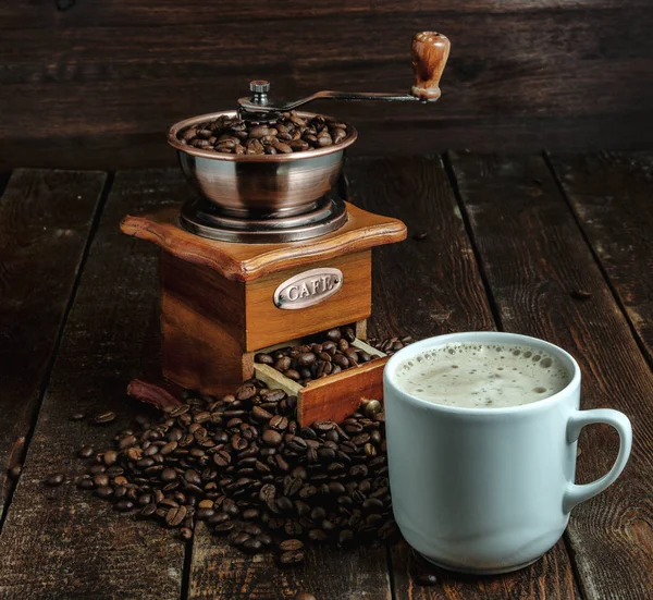 Xícara de café com moinho e feijão na mesa escura — Fotografia de Stock