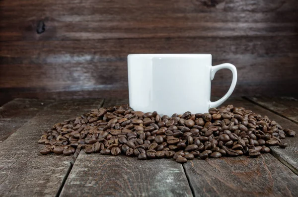 Filiżanka kawy z fasolą na ciemnym tle drewna — Zdjęcie stockowe