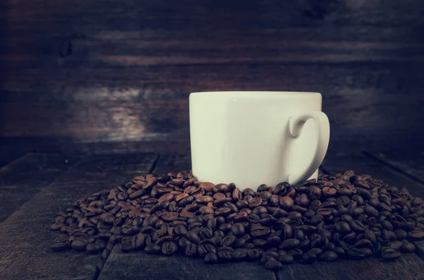 Caneca de café vintage com grãos no fundo de madeira escura — Fotografia de Stock