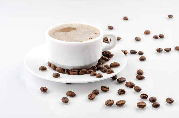 Copo de café branco com feijão no fundo branco — Fotografia de Stock