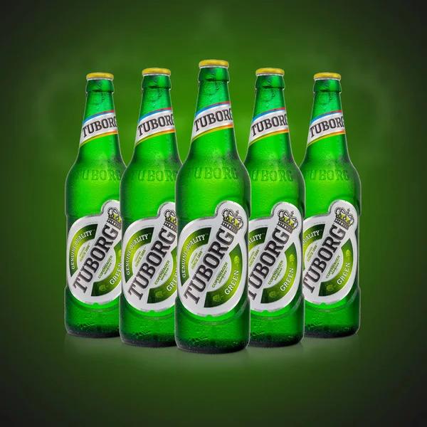 Redactionele foto van vijf koude flessen Tuborg glas bier op groene achtergrond — Stockfoto