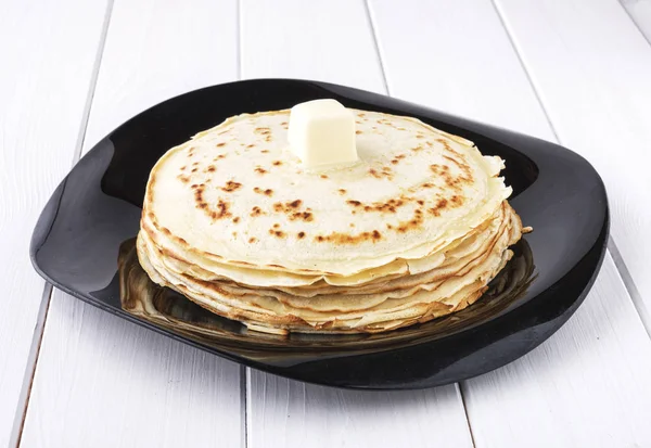 Pfannkuchen mit Butter in Platte auf weißem Hintergrund — Stockfoto