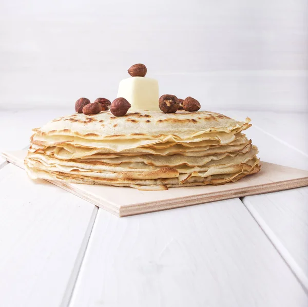 Nahaufnahme-Pfannkuchen mit Haselnuss und Butter auf weißem Hintergrund — Stockfoto