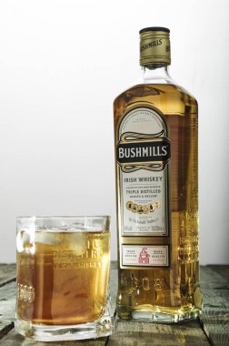 Bushmills viski cam ve şişe üzerinde yeşil ahşap masa