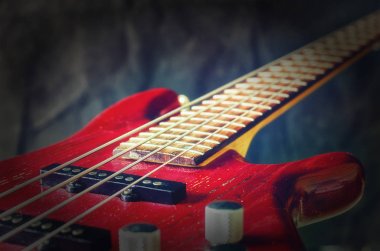 Koyu arka plan üzerinde yakın çekim kırmızı bas gitar. Skeç ile tonlama vintage