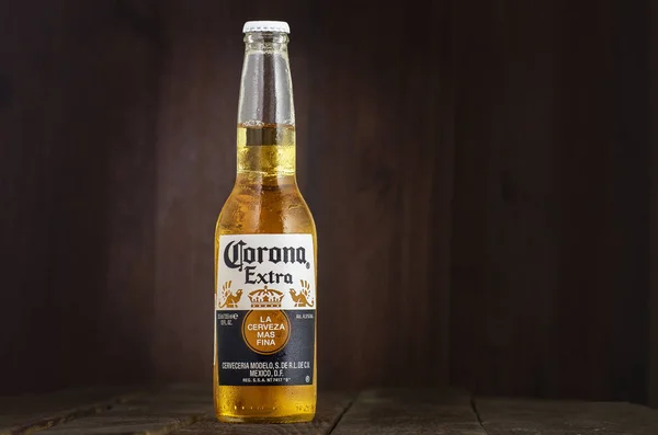 MINSK, BELARUS - JULI 10, 2017: Redaktionelt foto af flaske Corona Extra øl på træbaggrund, en af de mest solgte øl verden over er en bleg pilsner produceret af Cerveceria Modelo i Mexico - Stock-foto